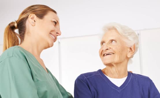 caregiver and her patient smiling at each other
